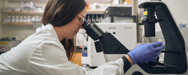 Zoetis scientist looking through microscope - Zoetis